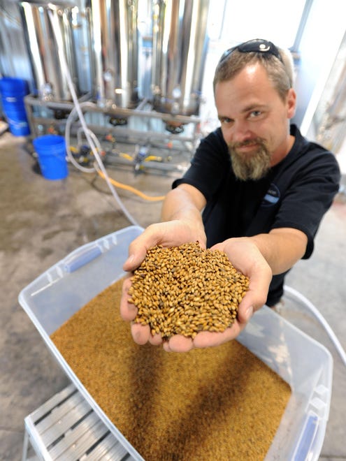 Mispillion River Brewing's Eric Williams shows off handfuls of malt, which gives beer its color and flavor.