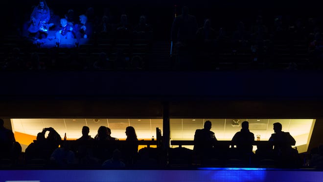 Attendees at the Super Bowl Opening night are silhouetted Monday at the Xcel Energy Center.