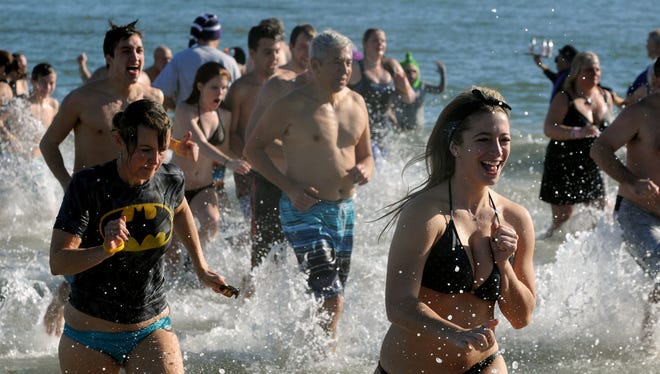 Chilled swimmers emerge from the Atlantic after diving into the ocean during the annual AGH Penguin Swim Thursday afternoon in Ocean City.