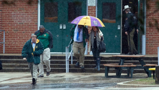 Teachers and school employees depart Great Mills High School, the scene of a shooting, March 20, 2018 in Great Mills, Md.  A teenager wounded a girl and a boy inside his Maryland high school Tuesday before an armed school resource officer was able to intervene, and each of them fired one more round as the shooter was fatally wounded, a sheriff said.  St. Mary's County Sheriff Tim Cameron said the student with the handgun was declared dead at a hospital, and the other two students were in critical condition. He said the officer was not harmed.