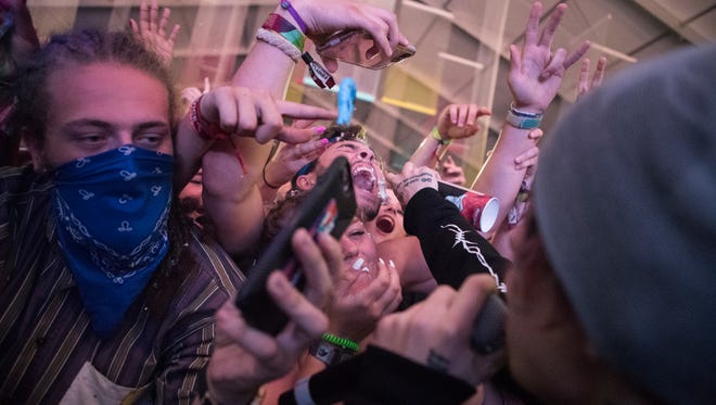 Lil Xan sprays whip cream into the mouths of fans during his performance during day 2 of Firefly Music Festival in Dover.