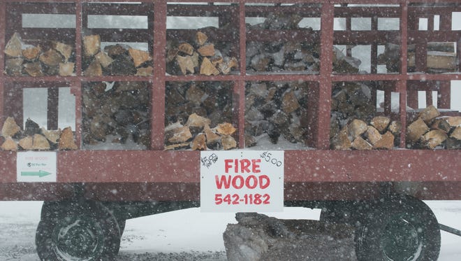 Snow starts to lay on fire wood that is for sale in Lewes.