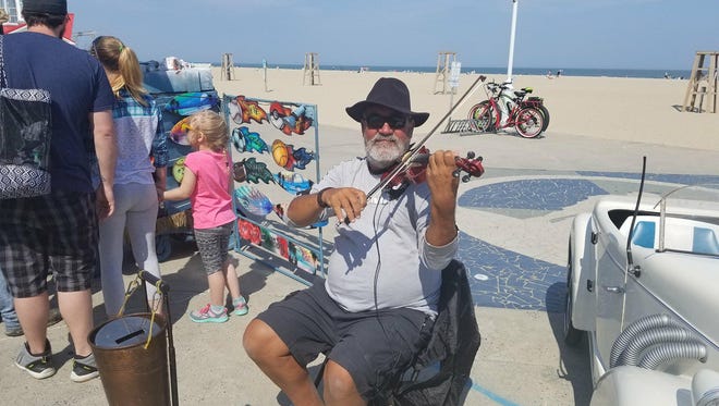 Lucian Ionescu poses with his violin on the Ocean City Boardwalk on May 12, 2018.