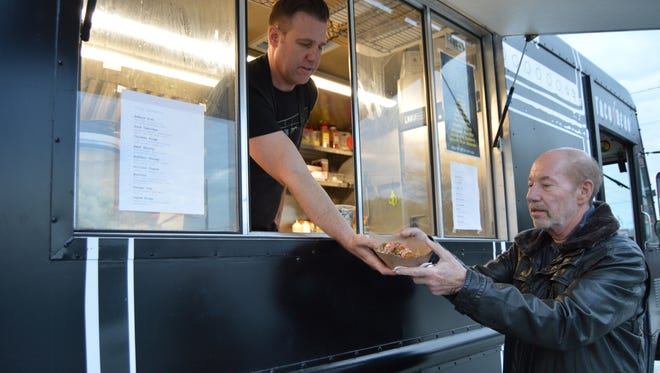 Billy Lucus, owner of Taco Reho food truck in Rehoboth, hands Tony Kornheiser his first fish tacos — ever.