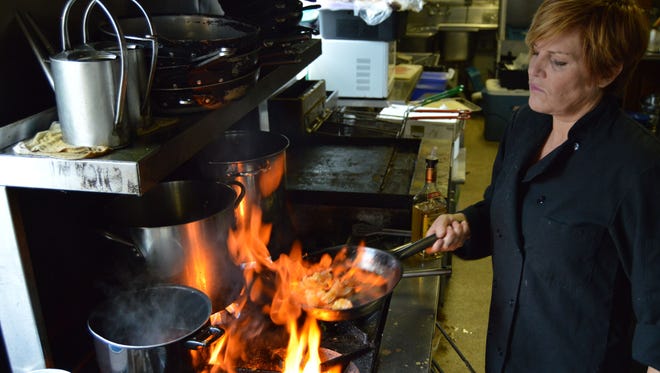 Gretchen Hanson, owner and executive chef at Hobos, prepares a fiery dish.