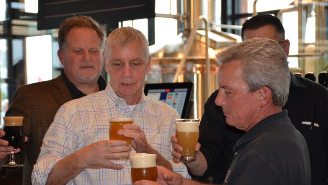 Owners of Iron Hill Mark Edelson, Kevin Finn, Kevin Davies pour the first draft beer from Iron Hill Rehoboth.