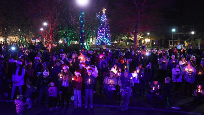 Carolers hold candles as they participate in the Caroling on the Circle in Georgetown.