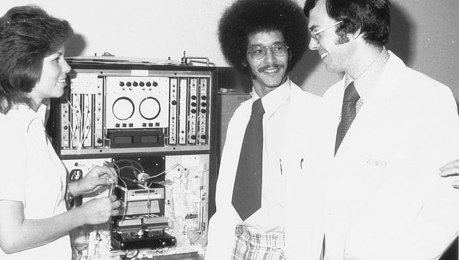 1974: Medical technology students examine a laboratory device at Salisbury University.