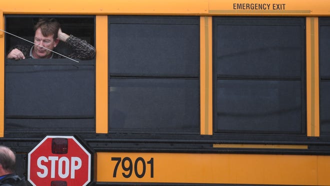 A man looks out of a school bus at Great Mills High School in Great Mills, Md. after a shooting at the school, March 20, 2018.