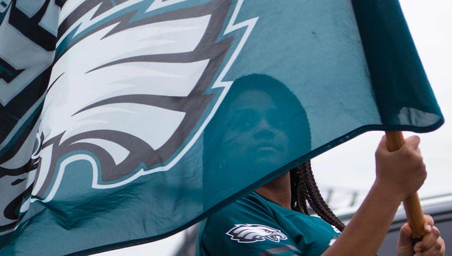 Taylor Yates, 12, of Philadelphia waves her Eagles flag around as she enjoys the tailgating party Sunday at Lincoln Financial Field.
