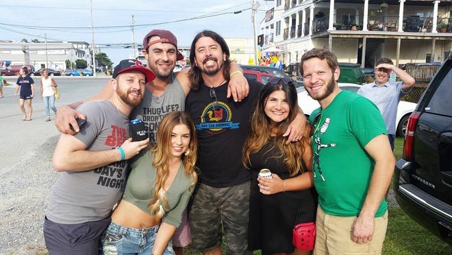 Foo Fighters' Dave Grohl poses with fans in Dewey Beach Saturday, July 30, 2016 including Debora Magalhães (front left).