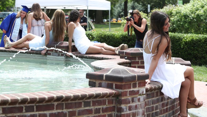 A fountain at the University of Delaware draws seniors in their last days at the school for final photos in the week leading up to commencement.