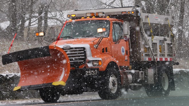 A DelDOT plow salts Adams Dam Road around noon as snow hits Northern Delaware starting Saturday morning.