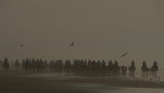 Saltwater Cowboys lead the northern herd of Chincoteague Ponies down the beach at Assateague Island, Va. on their way to the pony corral on Monday morning, July 25, 2016. The 91st Annual Chincoteague Pony Swim is Wednesday.