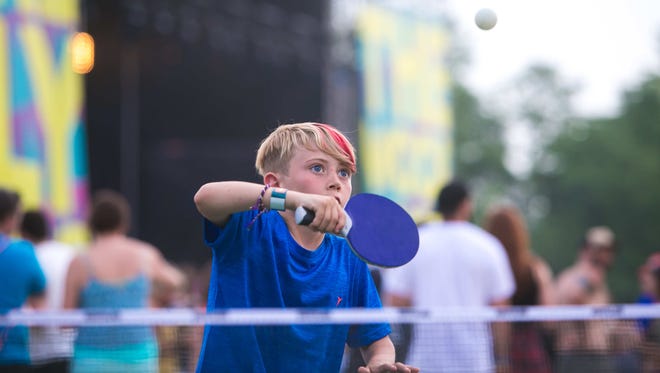 Dexter Martin-Hart, 9, of Maine plays ping pong with his mom Tanya Hart in the VIP section next to the Lawn Stage on day two of Firefly Music Festival Friday at The Woodlands in Dover.
