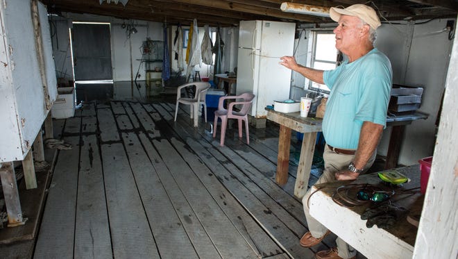 Craig Stevens stands inside of his Calvary Road fishing cabin on Sunday, Nov. 5, 2017. Because of the King Tide the back half of the room is partially flooded.