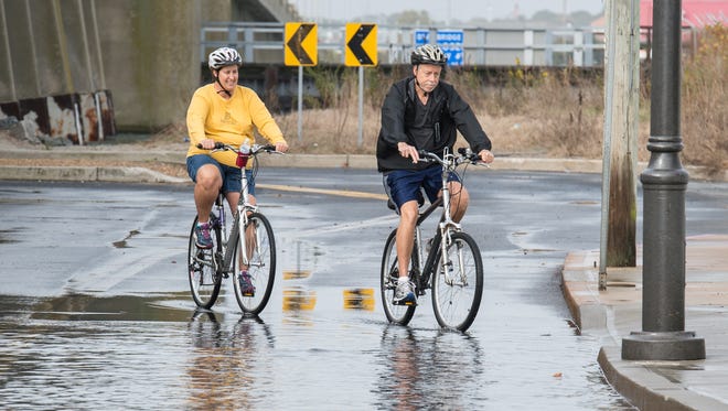 Two cyclists circumnavigate a flooded section of North Division Street and Saint Louis Avenue in Ocean City on Sunday, Nov. 5, 2017. Many roads in Ocean City were partially flooded due to the King Tide.