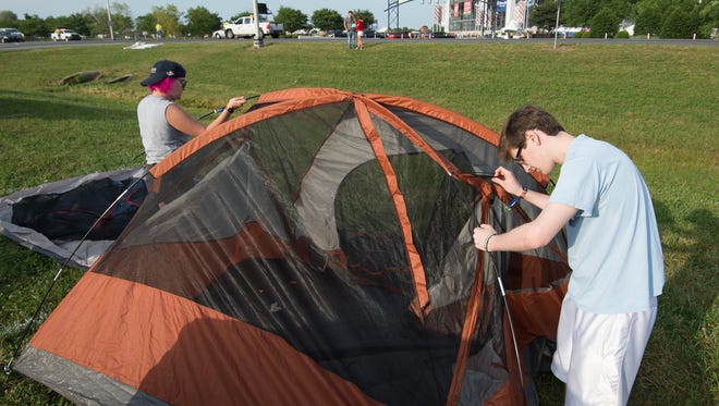 Haley Cupp, left, of Ridgely, Md., and Josh Betz of Huntingtown, Md., set up their campsite early Thursday morning at the Firefly Music Festival in Dover.