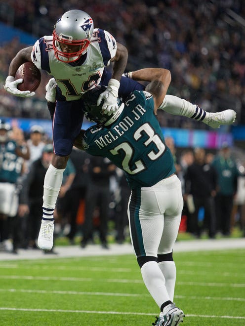 New England's Brandin Cooks is stopped airborne by the Eagles' Rodney McLeod Sunday at US Bank Stadium.