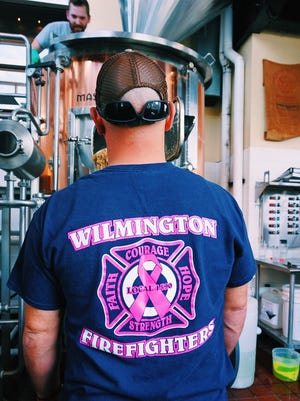 Wilmington firefighter Stephen Facciolo helps brew Iron Hill's Last Alarm IPA in October.