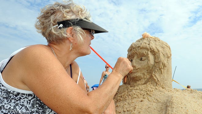 Sherri Miller from Boyerstown, PA. works on her "Neptunes Angel" as The 38th Annual Rehoboth Beach-Dewey Beach Chamber of Commerce Sandcastle Contest was held on Saturday, Sept. 10, 2016 at a new location on the south end of the beach near Funland under hot weather conditions.  Participants worked to create different castles and sculptures in the sand for judging in the late afternoon at which time trophy's ail be given out.