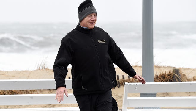 A boardwalk visitor tests staying upright against the high wind gusts on Rehoboth Beach.