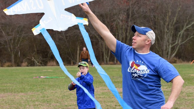 Todd Lawson from Harbeson, helps his son Cooper, 7 get their kite to fly, Despite cloudy and rainy weather, the 48th Annual Kite Festival was held on Friday March 25th at Cape Henlopen State Park near Lewes with a good crowd on hand flying all kinds of kites and creations.