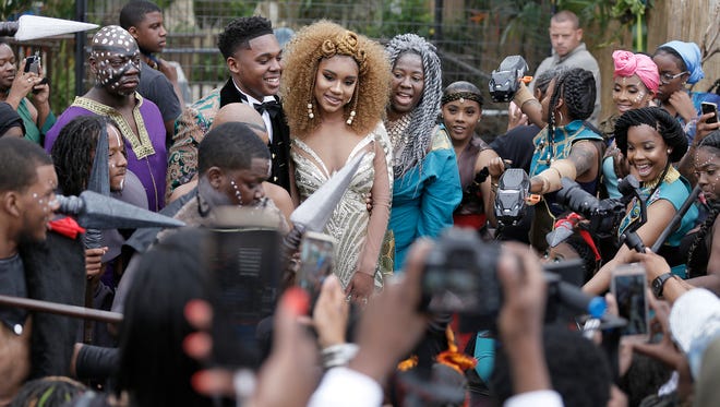 Quian Brown, Dayanna McBride and Saudia Shuler pose for photos in front of the black leopard during the Wakanda-themed prom send off on 22nd St. in North Phila., Pa. on June 6, 2018. (Elizabeth Robertson/The Philadelphia Inquirer via AP)