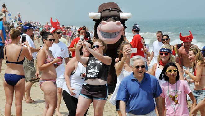 Fans take a selfie with the bull as he makes his way down Dewey Beach last year.