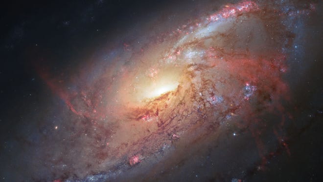 This image made by the NASA/ESA Hubble Space Telescope shows M106 with additional information captured by amateur astronomers Robert Gendler and Jay GaBany. Gendler combined Hubble data with his own observations to produce this color image. It is a relatively nearby spiral galaxy, a little over 20 million light-years away. The Hubble Space Telescope marks its 25th anniversary. A full decade in the making, Hubble rocketed into orbit on April 24, 1990, aboard space shuttle Discovery.   (NASA/ ESA/ Hubble Heritage Team (STScI/AURA), R. Gendler via AP) ORG XMIT: NY939