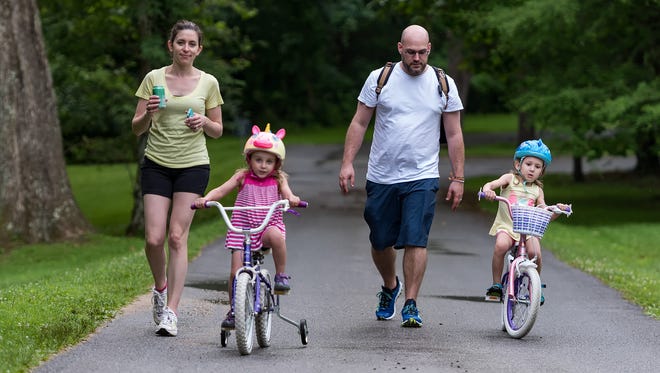 Laura and Mark Westmoreland of Wilmington and their two daughters, Addy (age 4, left) and Brynne (age 5), enjoy the Bike & Hike event at Hagley Museum in Wilmington despite some unplanned rain.