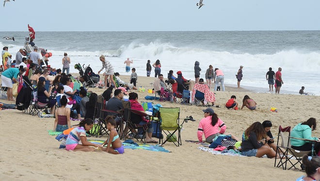 Swimming continues to be forbidden as vacationers make the most of the last day of the summer season by walking the boardwalk and watching the rough surf at Rehoboth Beach on Monday.