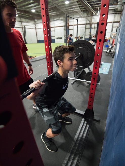 Jacob Simpson (13) completes a set of squats during a training session with Sports Specific Training at Slim's Sport Complex in Middletown.