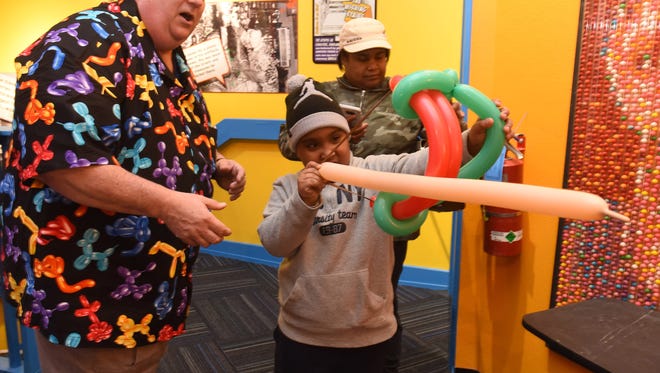 Mark Hoffman, left, the ballon maker, helps Gabriel Rodriguez, 8, of Berlin as his mom watches Tasha Brittingham shoot a bow and arrow made from balloons at the Odditorium Grand Reopening of Ripley's Believe It or Not! on the Boardwalk in Ocean City Saturday, March 10, 2018. The attraction has remodeled, with added new exhibits to the boardwalk staple.