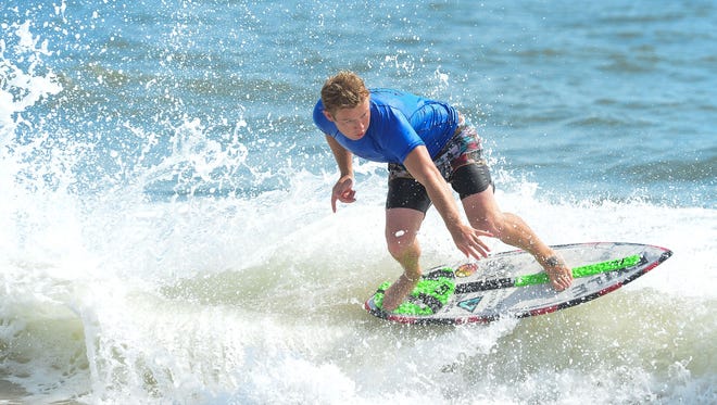 Sam Stinnett, Dana Point, Ca., catches a wave during the Men's Pro Division heat in the semifinals of the Skim USA Association ZAP Pro/Am Skimboarding Competition in Dewey Beach, De. on Friday, August 11, 2017.