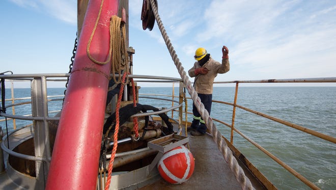 Pablo Solano, a drag tender with Great Lakes Dredge & Dock Company, connects the probe to the bell to begin the process of pumping sand onto Dewey Beach.