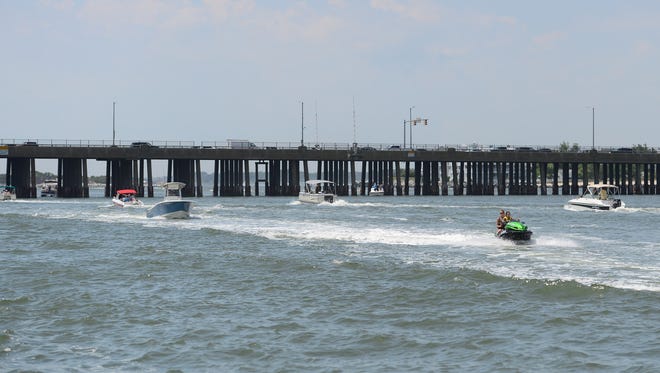 Boats travel from the bay to the ocean under neath the Rt. 50 bridge in Ocean City, Md. during the holiday week on  July 3, 2017.