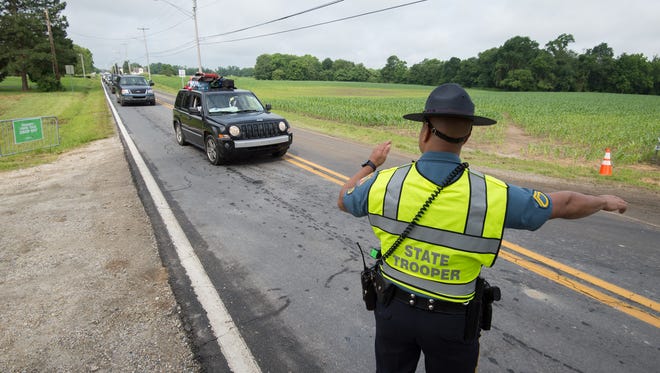 Delaware State Trooper CPL / 1 Will Miller directs Firefly Music Festival camping traffic along Leipsic Road in Dover.