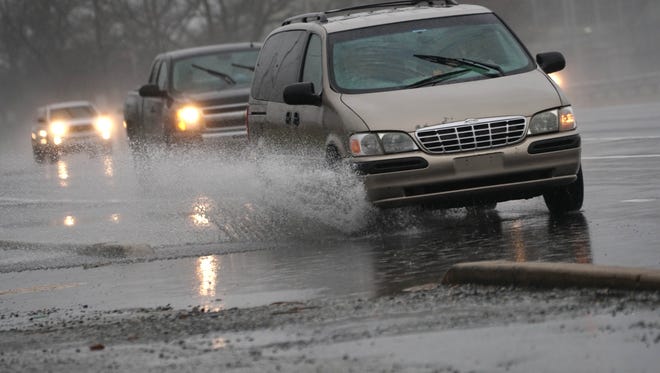 Vehicles drive through pooling water along the northbound lanes of Rt. 13 near the Rt. 141 overpass on Monday afternoon.