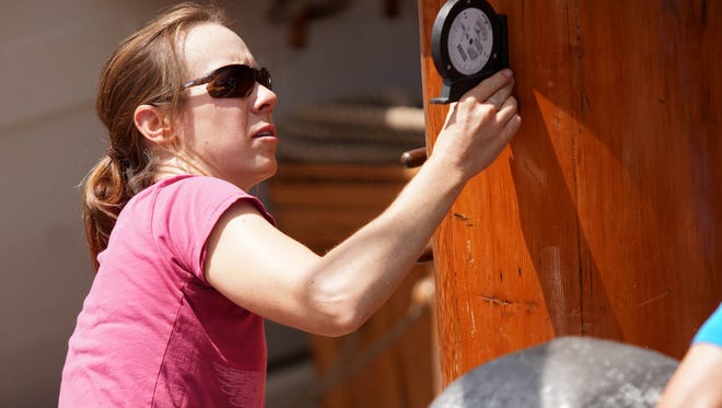 Capt. Sharon Dounce measures the angle of the main mast on the Kalmar Nyckel after it was reinstalled on the ship from being off for maintenance.