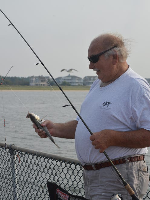 Roger Leonard, of Lewes, lands a croaker at the Cape Henlopen Fishing Pier. The pier, closed since October for structural repairs, reopened Friday afternoon.
