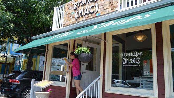 An employee stuffs menus outside grandpa(MAC) restaurant, a new gourmet pasta carryout located in downtown Rehoboth.