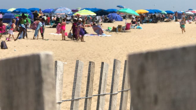 Beach goers seek shelter from the heat on Rehoboth Beach on July 14, 2017.