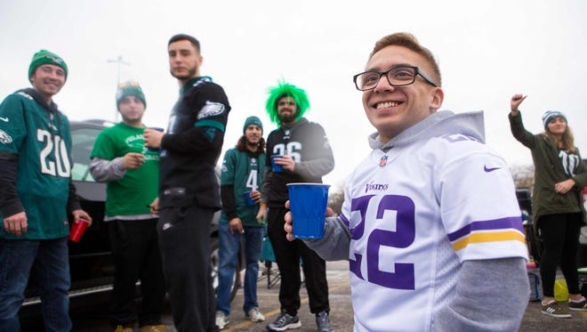 Gabriel Ribeiro of Virginia smiles as he's surrounded by Eagles fans during tailgating Sunday at the NFC Championship game at Lincoln Financial Field.
