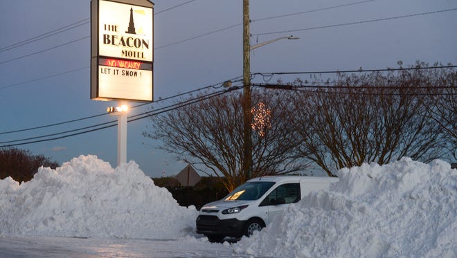 The Beacon Motel sign says "Let it Snow!" surrounded by large mounds of snow following the blizzard on Friday, Jan. 5, 2018.