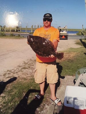 Jessie Kilgore pounds the flounder with a catch of the day measuring 26.5 inches and 8 pounds, 4 ounces.