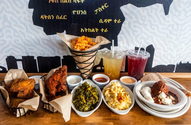 [Left to right] A sampling of Alicha Lemon Turmeric wings, 
Awaze Spicy Berbere wings, fries, collard greens, Aida's Mac N Cheese, and Doro Wot, with all four house sauces, a Birz-fermented honey drink, and a hibiscus iced tea at Doro Bet in Philadelphia on Wednesday, Dec. 20, 2023.

Daniella Heminghaus