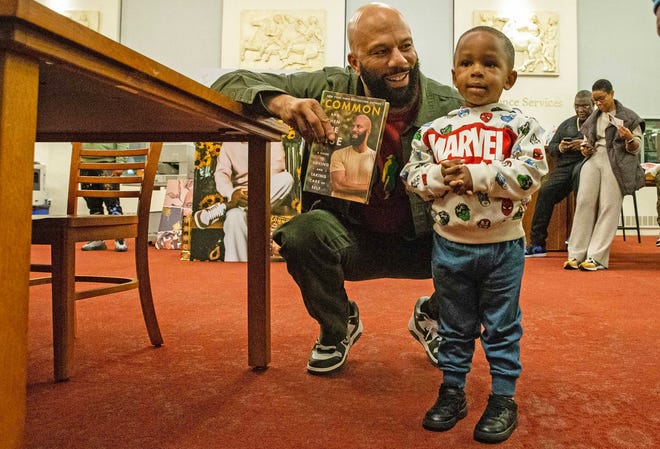 Common, rapper, actor, writer and activist, poses for a photo with his young fan, Jackson Conley, 3, during a book signing event for his book And Then We Rise: A Guide to Loving and Taking Care of Self at the Wilmington Public Library on Friday, Jan 26, 2024. A capacity crowd of approximately 350 people attended.