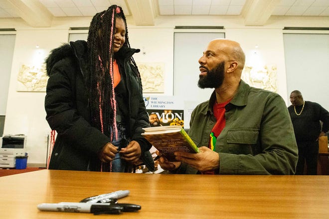 From left, Ceonni Cannon, 18, interacts with, and gets her book signed by, Common, rapper, actor, writer and activist, during a book talk and signing event for his book And Then We Rise: A Guide to Loving and Taking Care of Self at the Wilmington Public Library on Friday, Jan 26, 2024. A capacity crowd of approximately 350 people attended.