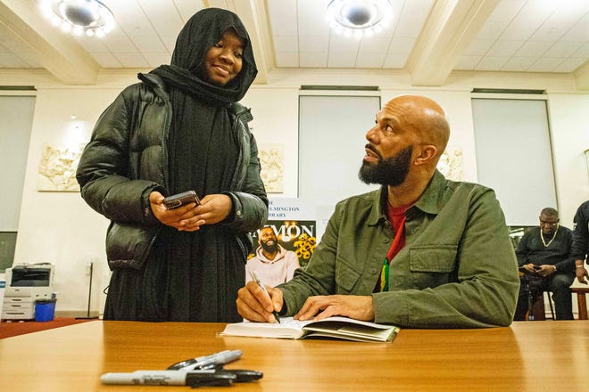 From left, Saige Everett, 18, interacts with, and gets her book signed by, Common, rapper, actor, writer and activist, during a book talk and signing event for his book And Then We Rise: A Guide to Loving and Taking Care of Self at the Wilmington Public Library on Friday, Jan 26, 2024. A capacity crowd of approximately 350 people attended.